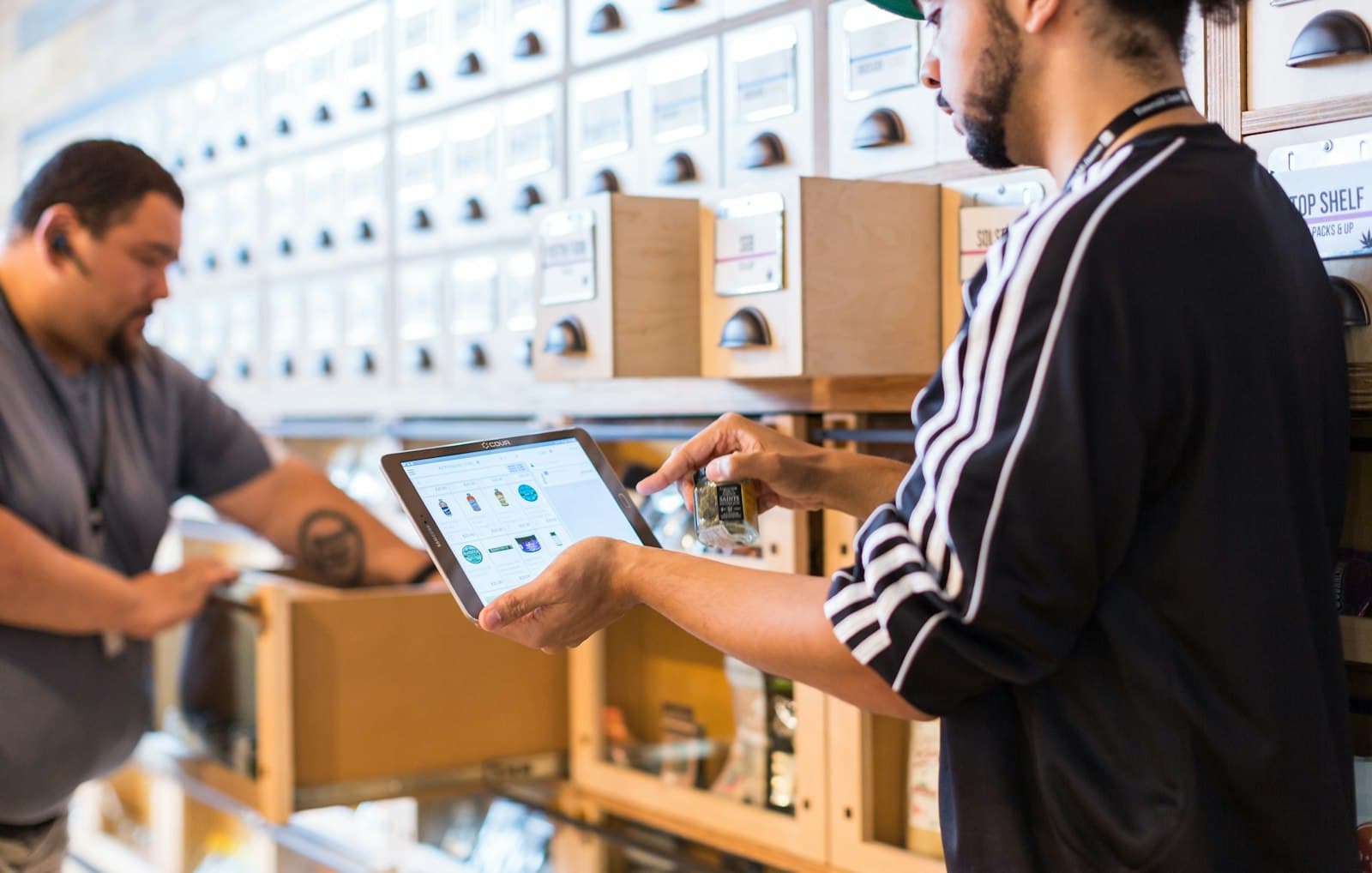 A team member at a service counter checking an order on a tablet.